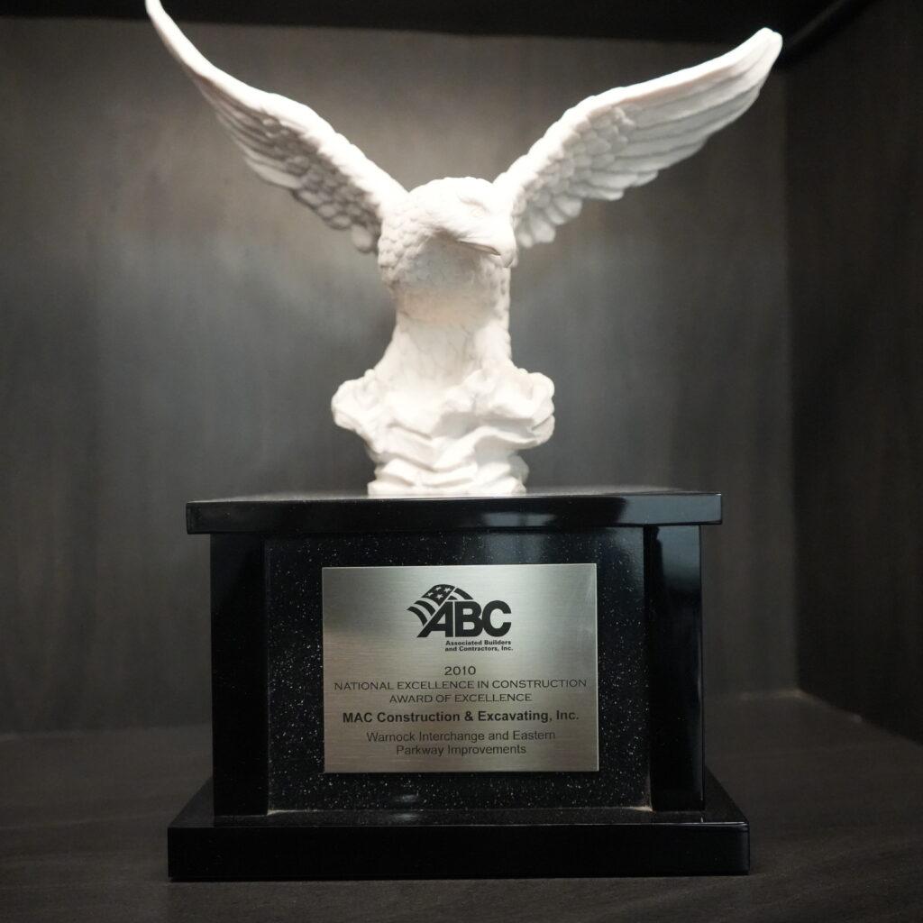 White winged statue atop a black pedestal, with an ABC award plaque for national excellence in construction (2010).